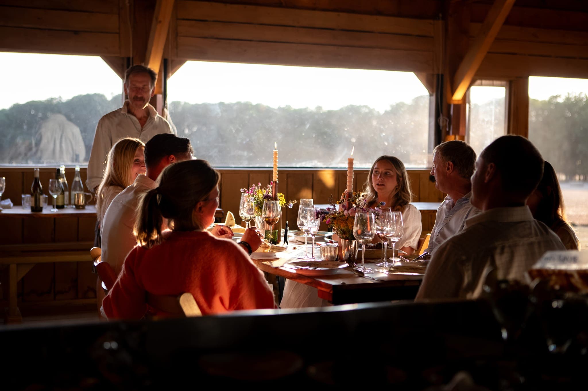Guests at their tables inside The Copse as the sun drops over the fields.